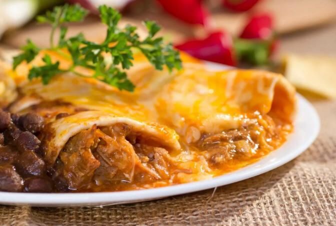 Enchiladas plated with rice and beans